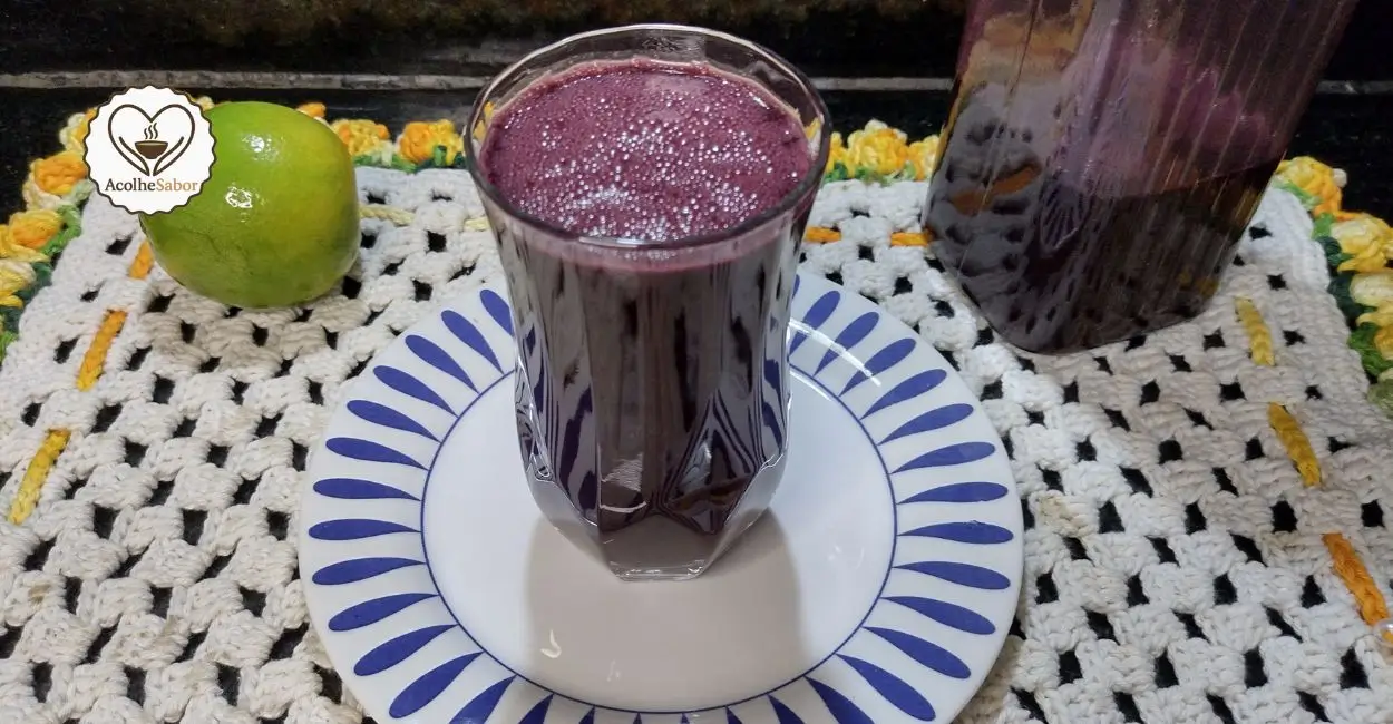 Suco de açaí com laranja cremoso em copo de vidro.