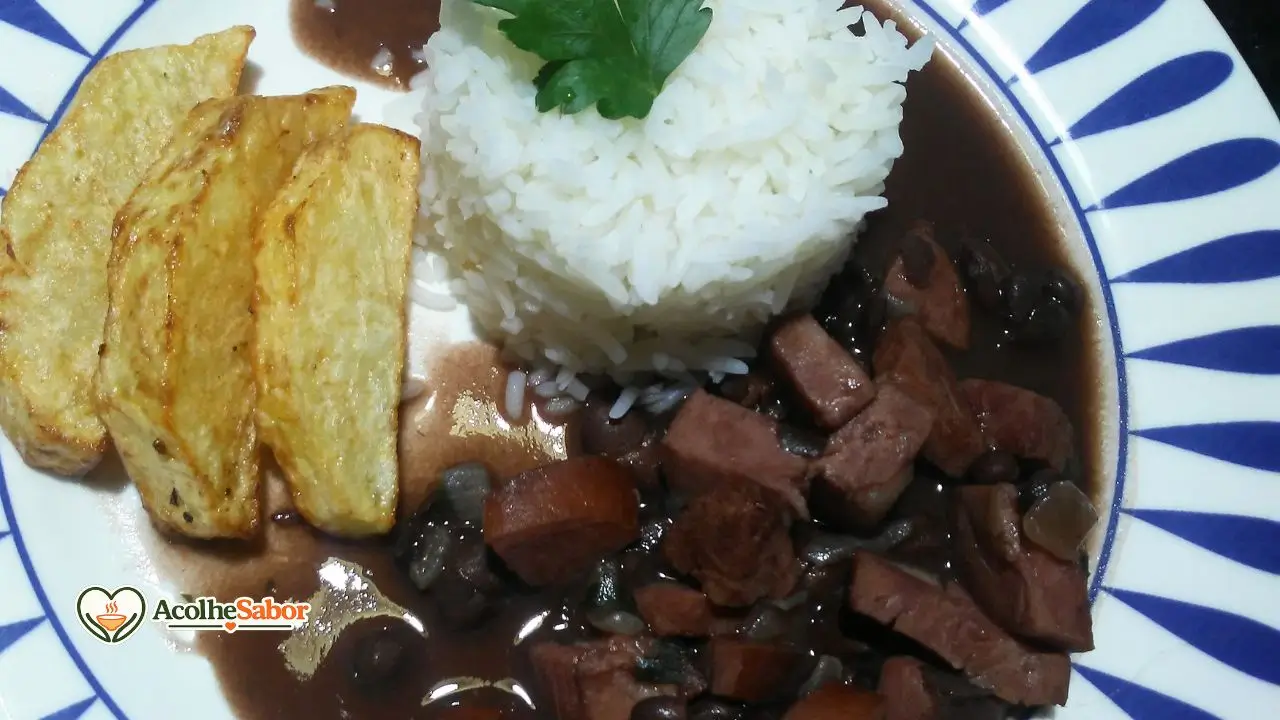 Feijoada light sem lactose servida em prato fundo com caldo encorpado, feijão, bacon e linguiça calabresa.