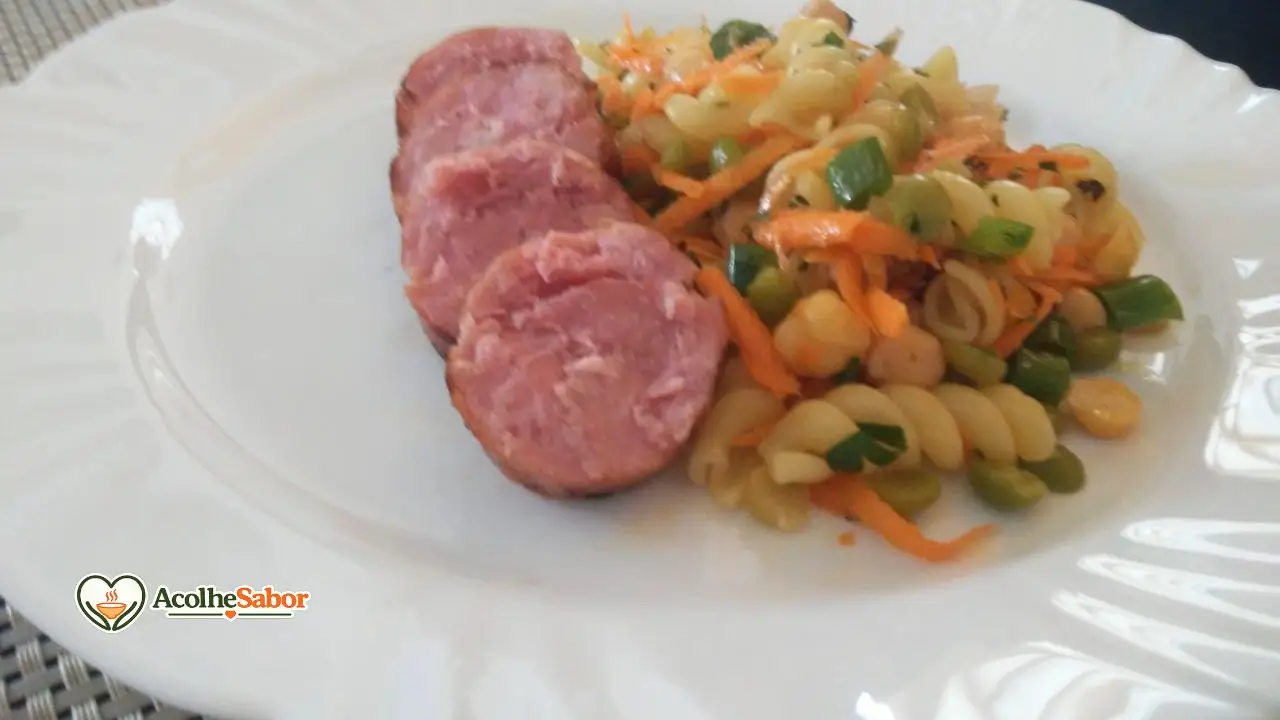 Salada de macarrão para churrasco sem lactose preparada com macarrão parafuso, grão-de-bico, ervilha, cenoura ralada e temperos.